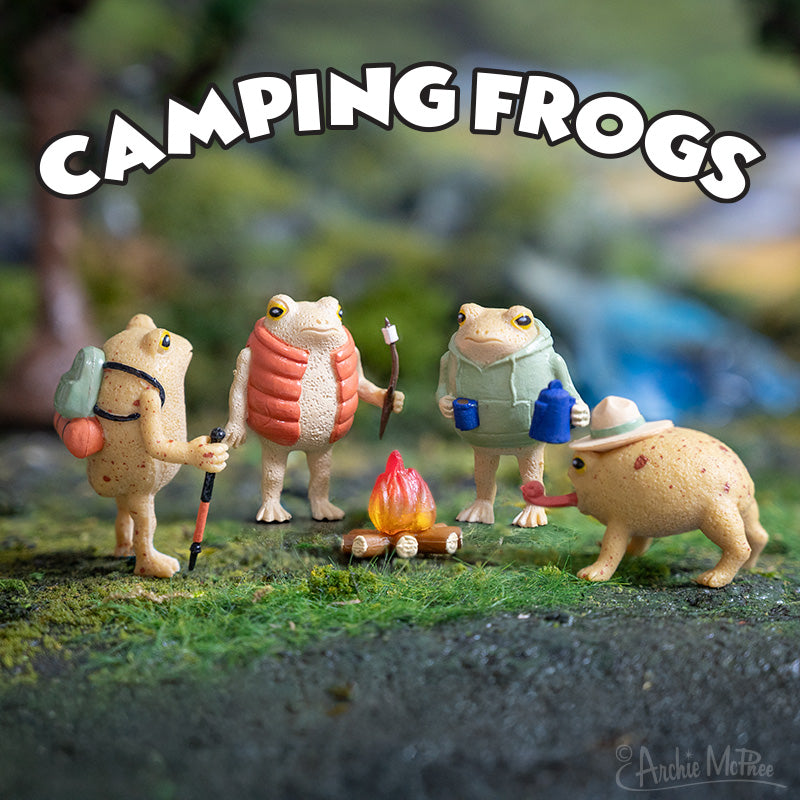 Four frogs with camping gear gather around a campfire toy, beneath the Camping Frogs title.