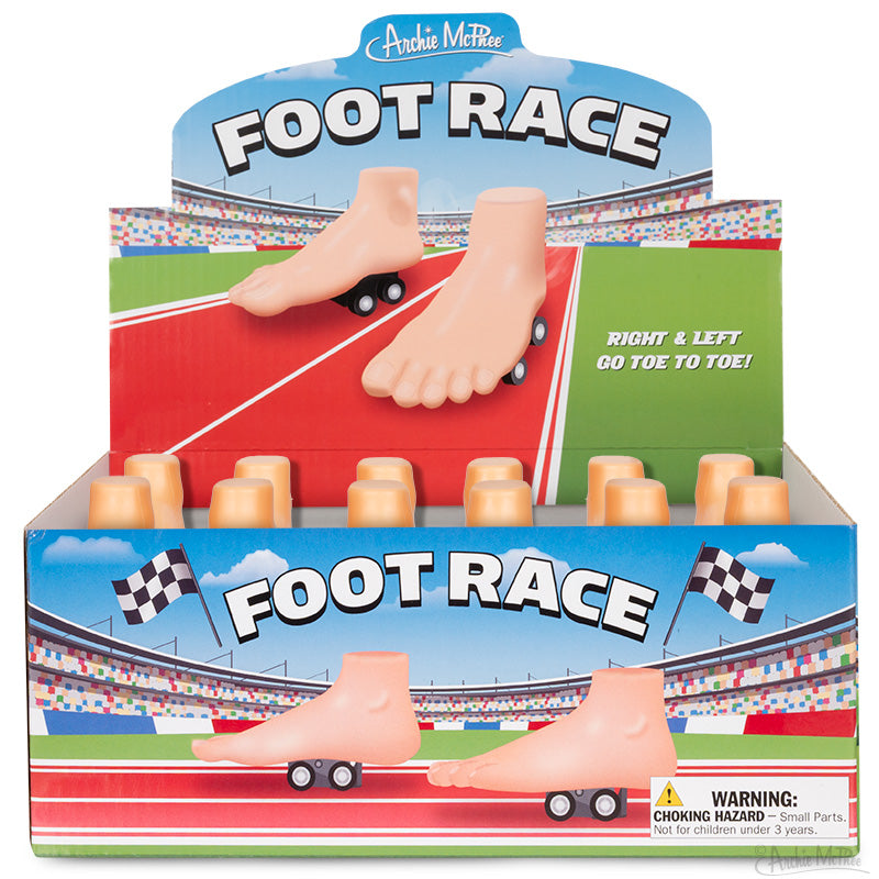 The Foot Race display box features plastic feet racers on wheels, set against a racetrack background with checkered flags.