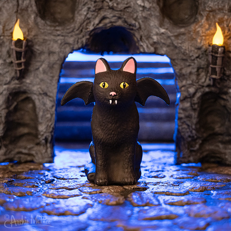 Black Goth Cat Ornament with yellow eyes and bat wings in a cave scene