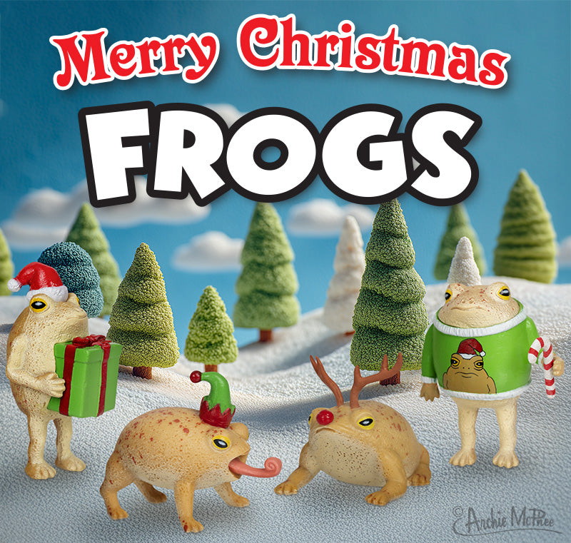 The Merry Christmas Frogs set features four vinyl rain frogs in festive costumes with gifts, trees, snow, and Merry Christmas FROGS text—a charming holiday decor collection.