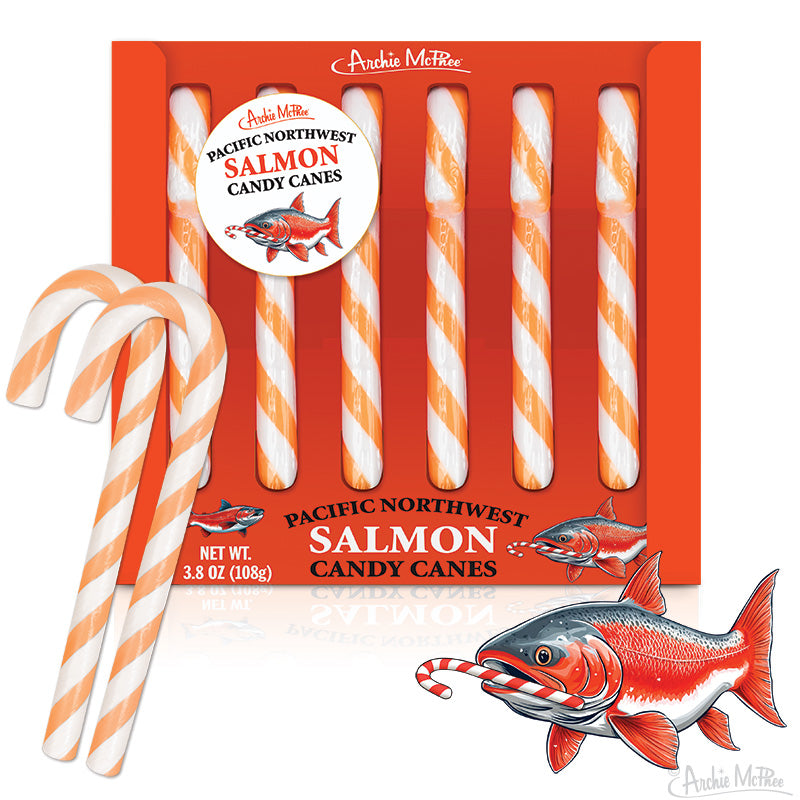 A box of Pacific Northwest Salmon Candy Canes features orange and white striped canes, two loose canes, an illustrated box, and a cartoon salmon.